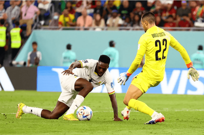El delantero de Ghana sorprende al arquero de Portugal.